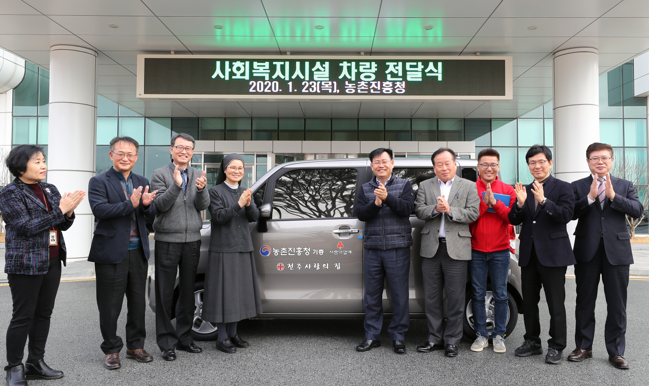 김경규(오른쪽 다섯번째) 농촌진흥청장이 23일 전북 전주 덕진구 본청에서 진행된 사회복지시설 차량 전달식에서 기념촬영을 하고 있다.［농촌진흥청 제공 ］