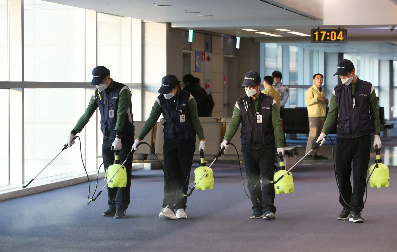 지난 23일 오후 인천국제공항 1터미널 입국장에서 인천공항 위생소독용역 직원들이 '우한(武漢) 신종 코로나바이러스 폐렴' 유입에 대비해 소독 작업을 하고 있다. [사진=연합]
