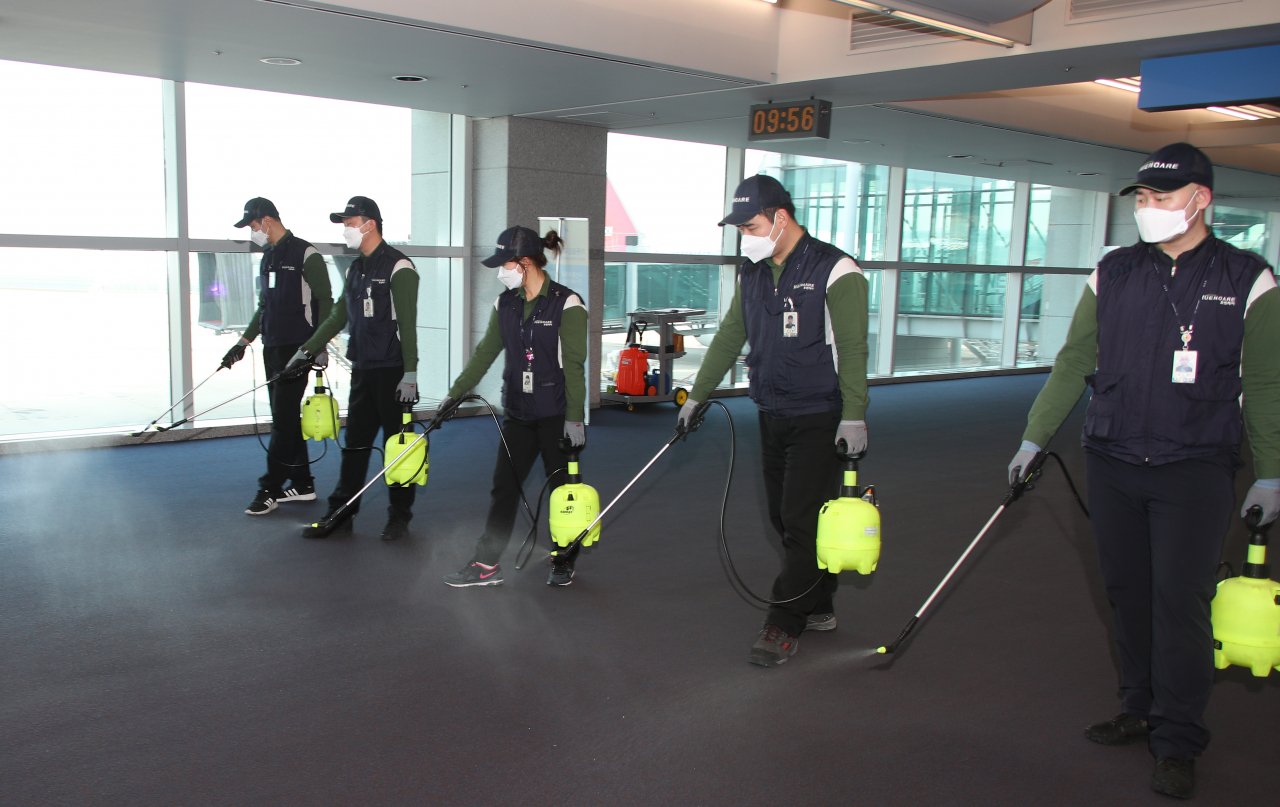 설 명절 연휴 첫날인 24일 인천국제공항 입국 통로에서 위생소독용역 직원들이 신종 코로나바이러스 유입에 따른 소독 작업을 하고 있다. [연합]