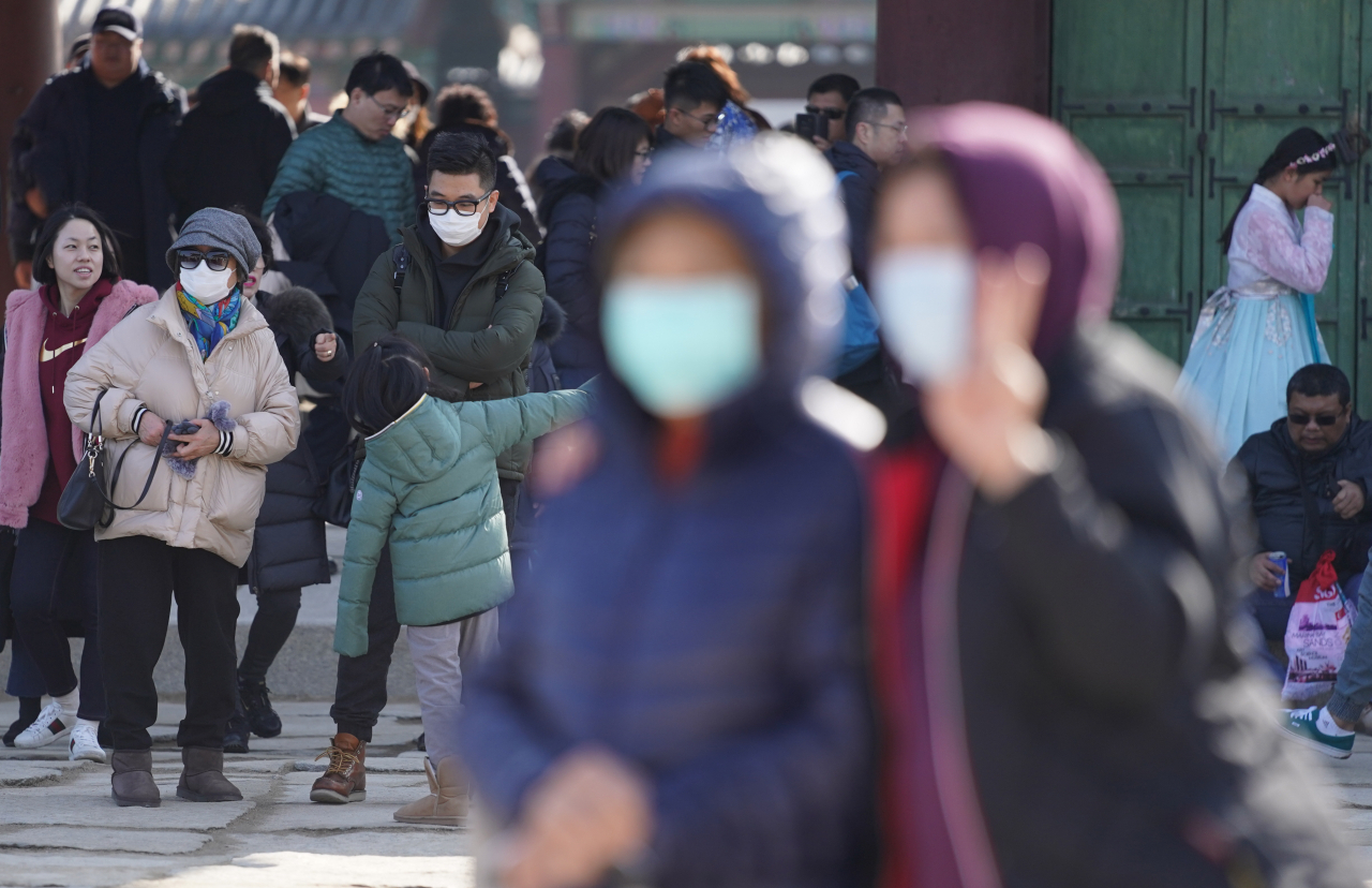 설 연휴 사흘째이자 국내에서 세 번째 우한 폐렴 확진 환자가 발생한 26일 서울 경복궁을 찾은 관람객들이 마스크를 쓰고 궁중을 둘러보고 있다. 연합뉴스