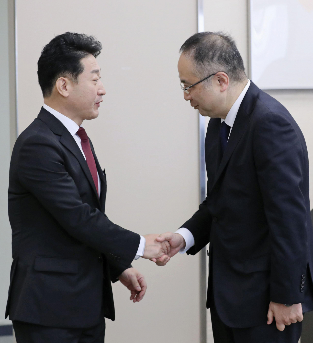 제7차 한일 수출관리 정책대화의 한국 수석대표인 이호현 산업통상자원부 무역정책관(왼쪽)이 지난달 16일 오전 정책대화 장소인 일본 경제산업성 본관 17층 제1특별회의실에서 일본 측 수석대표인 이다 요이치(飯田陽一) 경제산업성 무역관리부장과 악수하고 있다. ［연합］