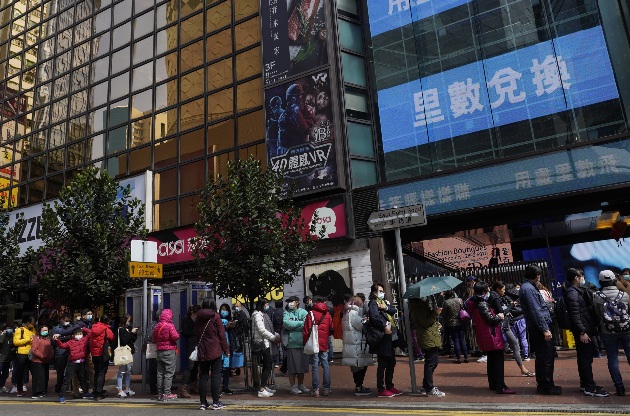 ‘우한 폐렴’의 공포가 덮친 홍콩의 시민들이 마스크를 사기 위해 길게 줄을 서고 있다. [AP]