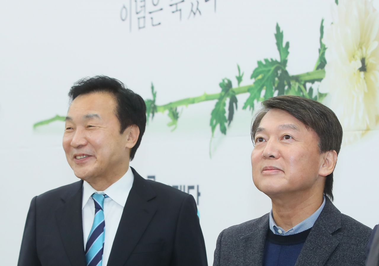 바른미래당 안철수 전 대표가 27일 국회에서 손학규 대표와 인사한 뒤, 언론 퇴장을 기다리며 손 대표와 함께 찍은 사진을 바라보고 있다. [연합]
