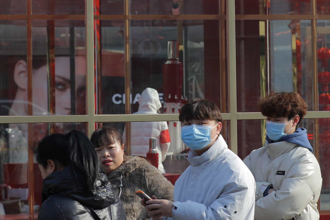지난 22일 중국 베이징에서 사람들이 마스크를 착용하고 있는 모습. [EPA/WU HONG]