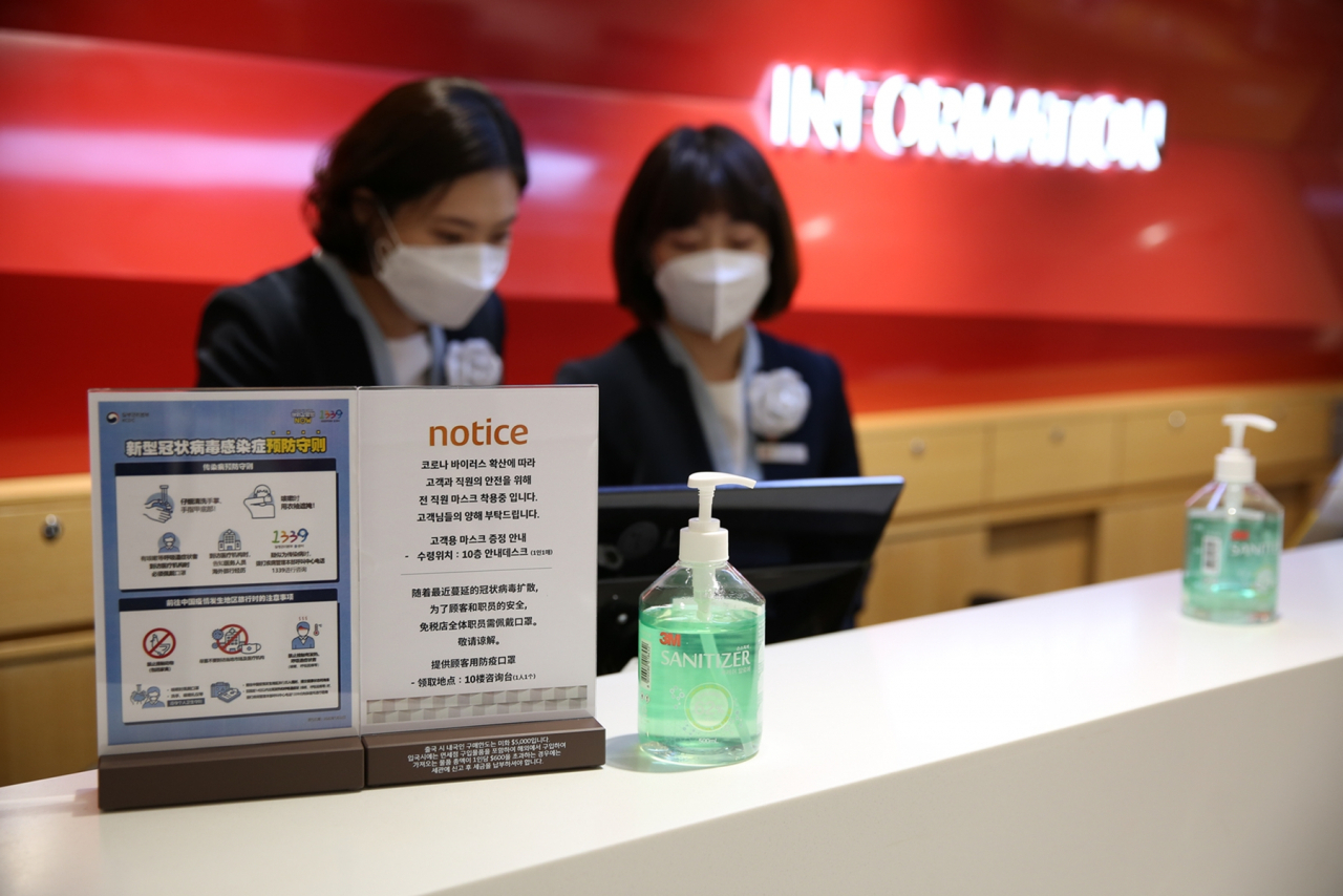 롯데면세점 직원들이 서울 소공동에 있는 명동본점 내 안내데스크에서 마스크를 착용하고 근무 중이다. 롯데면세점은 최근 이갑 대표이사를 좌장으로 한 비상대책위원회를 구성하고, 고객 응대 직원들의 마스크 사용을 의무화하는 내용의 대책을 마련했다. [사진제공=롯데면세점]