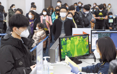 신종 코로나바이러스 감염증인 ‘우한 폐렴’ 공포가 확산하는 가운데 28일 부산 강서구 김해공항 입국장에서 중국발 승객들이 검역대를 통과하고 있다. [연합]