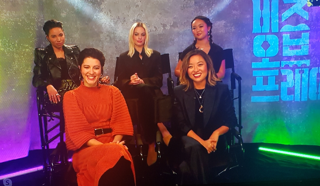 Screen shows casts of “Birds of Prey,” (from top left) Jurnee Smollett-Bell, Margot Robbie, Ella Jay Basco, (bottom left) and Mary Elizabeth Winstead, seen seated with director Cathy Yan (bottom right) during video press conference held in Seoul on Tuesday. (Warner Bros. Korea)