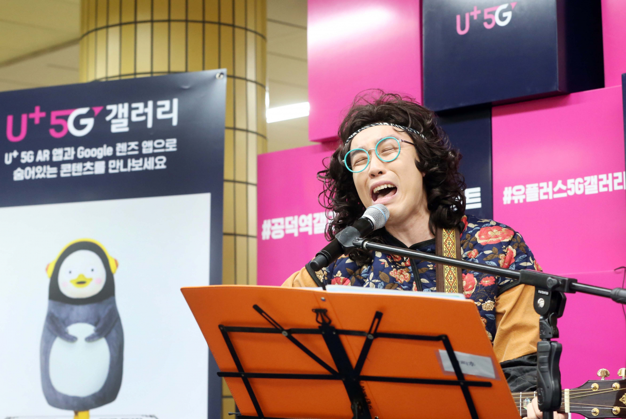카피추가 U+5G 갤러리 퇴근길 콘서트에서 본인의 히트곡 ‘선릉역으로’를 개사한 ‘공덕역으로’를 부르고 있다. [LG유플러스]