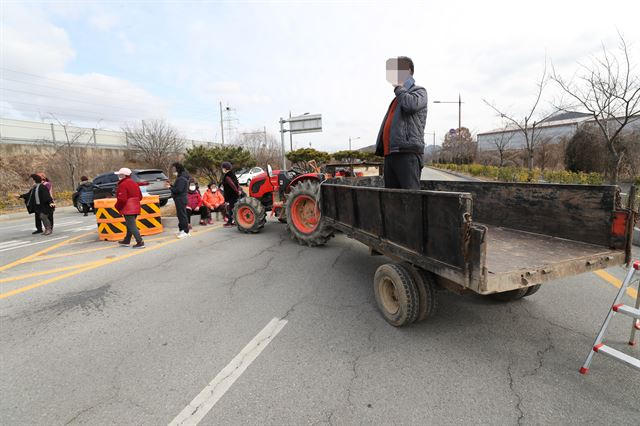 정부가 충남 아산과 충북 진천 공무원 교육시설에 우한 교민을 격리수용 할 것으로 알려진 지난 29일 오후 아산 주민들이 농기계로 경찰인재개발원 진입로를 가로막고 있다. [연합]