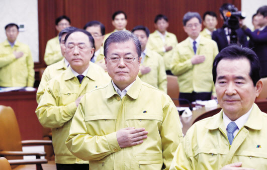문재인 대통령이 30일 오전 정부서울청사에서 열린 신종 코로나바이러스 감염증 대응 종합 점검회의에 앞서 국기에 경례하고 있다. [연합]