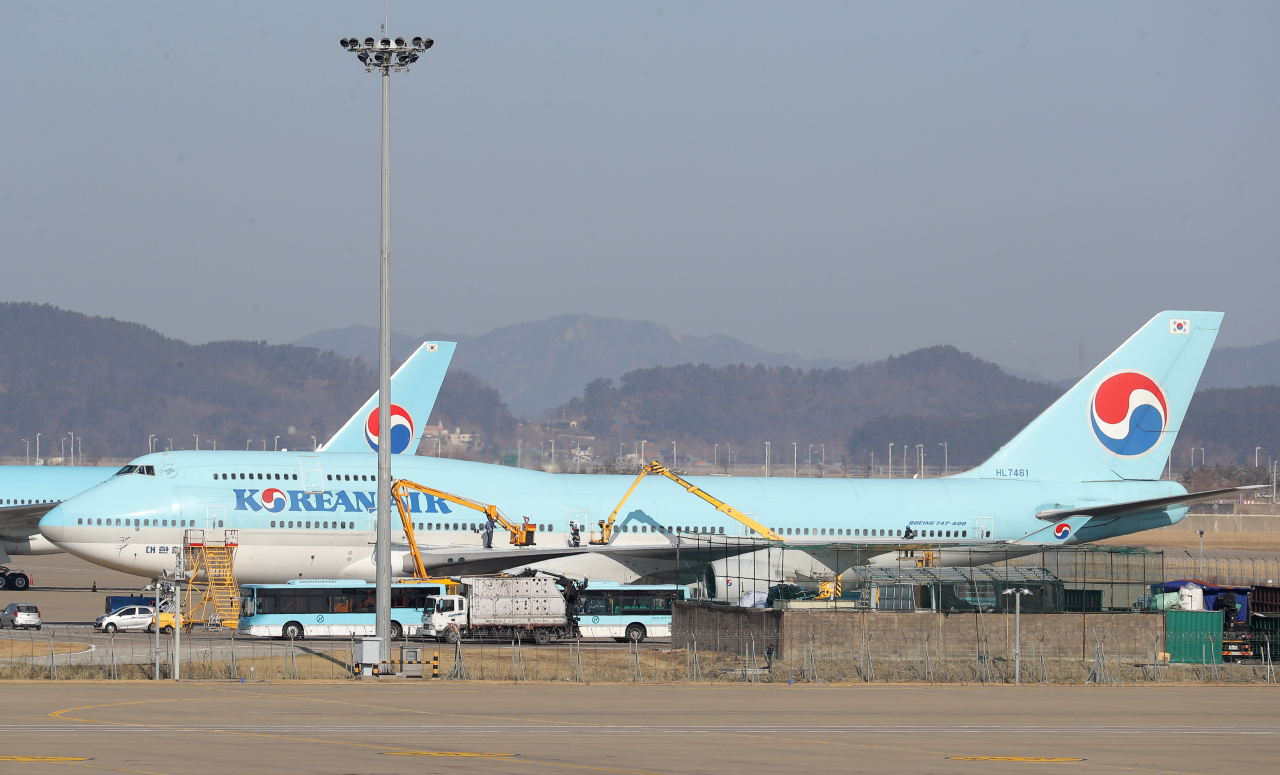 중국 우한 거주 한국 교민 수송을 위한 전세기 운항 일정이 지연된 가운데 30일 오후 인천국제공항 대한항공 계류장에서 관계자들이 우한행 전세기로 추정되는 KE9883-HL7461편을 청소하고 있다. [연합]