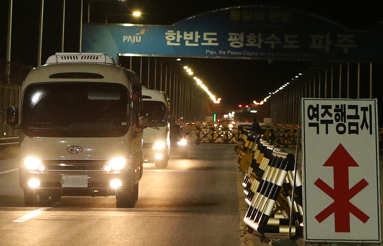 개성 남북공동연락사무소 남측 인력을 태운 차량이 30일 오후 경기도 파주 통일대교를 통과하고 있다. 통일부는 신종코로나 바이러스 위험이 완전히 해소될 때까지 연락사무소를 잠정 중단하기로 하고 현재 개성연락사무소에 상주 중인 남측 인력은 58명 전원이 철수한다고 밝혔다. [연합]