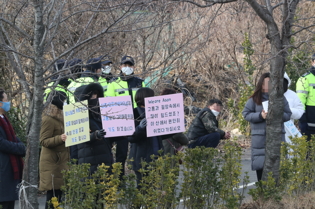 신종 코로나바이러스 감염증 발병지인 중국 후베이성 우한에서 귀국한 교민들을 태운 미니버스가 31일 임시생활시설로 지정된 충남 아산 경찰인재개발원에 도착하자 일부 주민들이 격려의 피켓을 들고 응원하고 있다. [연합]