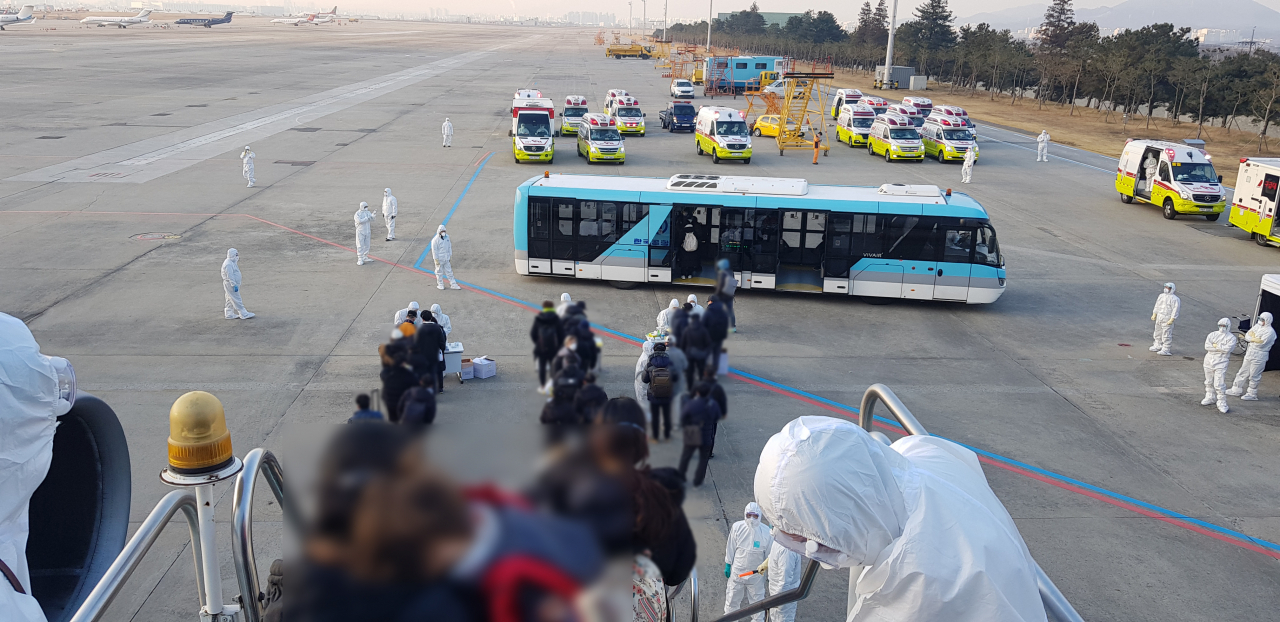 31일 오전 중국 후베이성 우한에서 1차 정부 전세기를 타고 김포공항에 도착한 교민들이 비행기에서 내리고 있다. [연합]