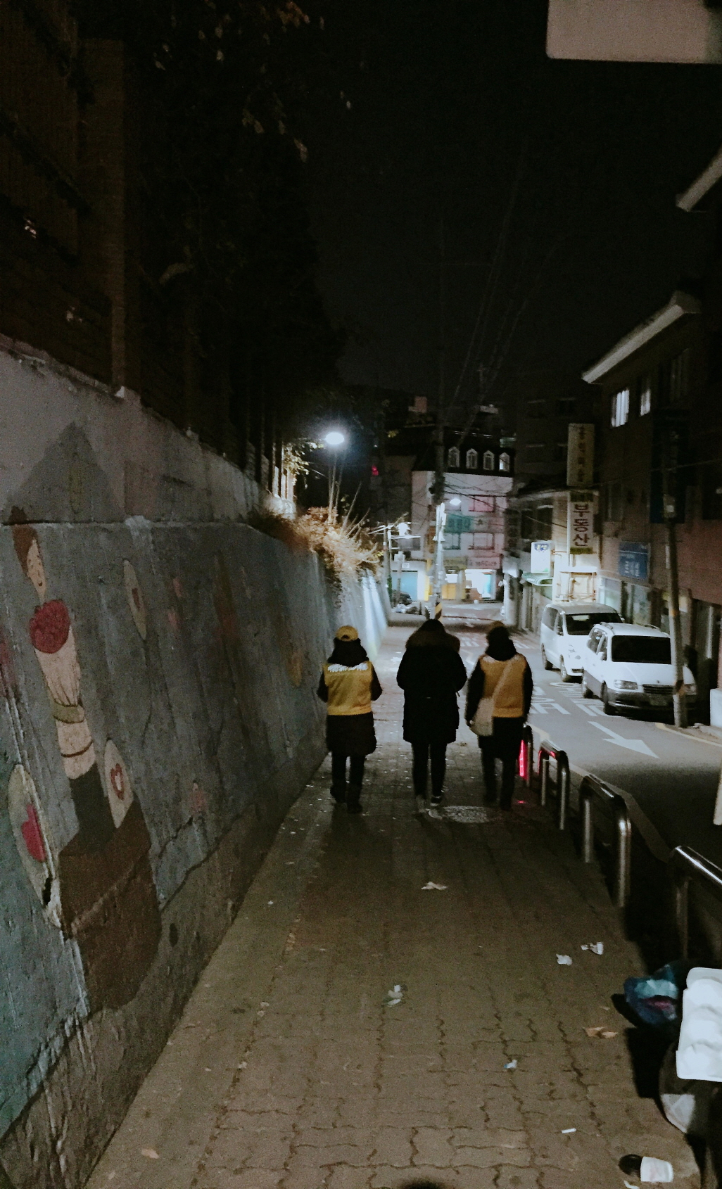 지난해 겨울 안심귀가스카우트 대원들이 늦은 밤 한 여성주민의 귀가에 동행하고 있다. [금천구 제공]