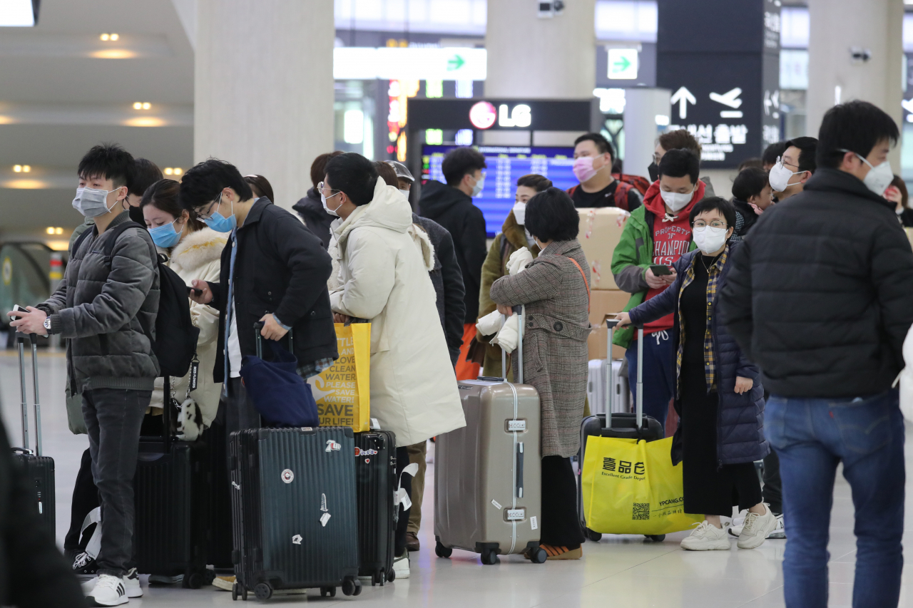 신종 코로나바이러스 감염 공포가 확산하는 가운데 3일 오전 제주국제공항 출국장에서 중국 상하이로 가는 항공기의 승객들이 마스크를 쓴 채 수속을 기다리고 있다. 연합뉴스
