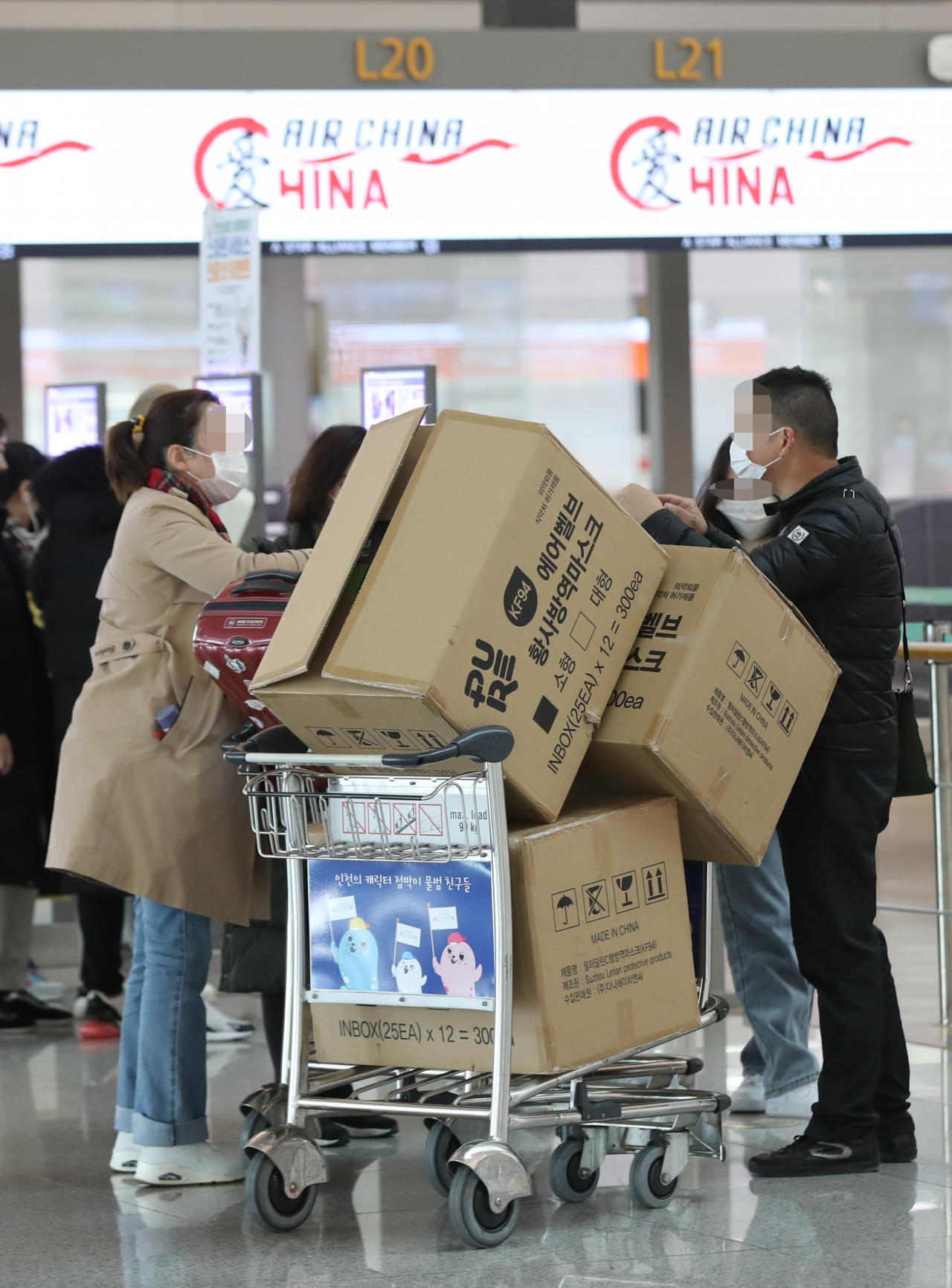 3일 오후 인천 중구 인천국제공항 제1터미널에서 중국인 여행객들이 마스크 박스가 실린 카트를 밀고 탑승 수속대로 향하고 있다. [연합]
