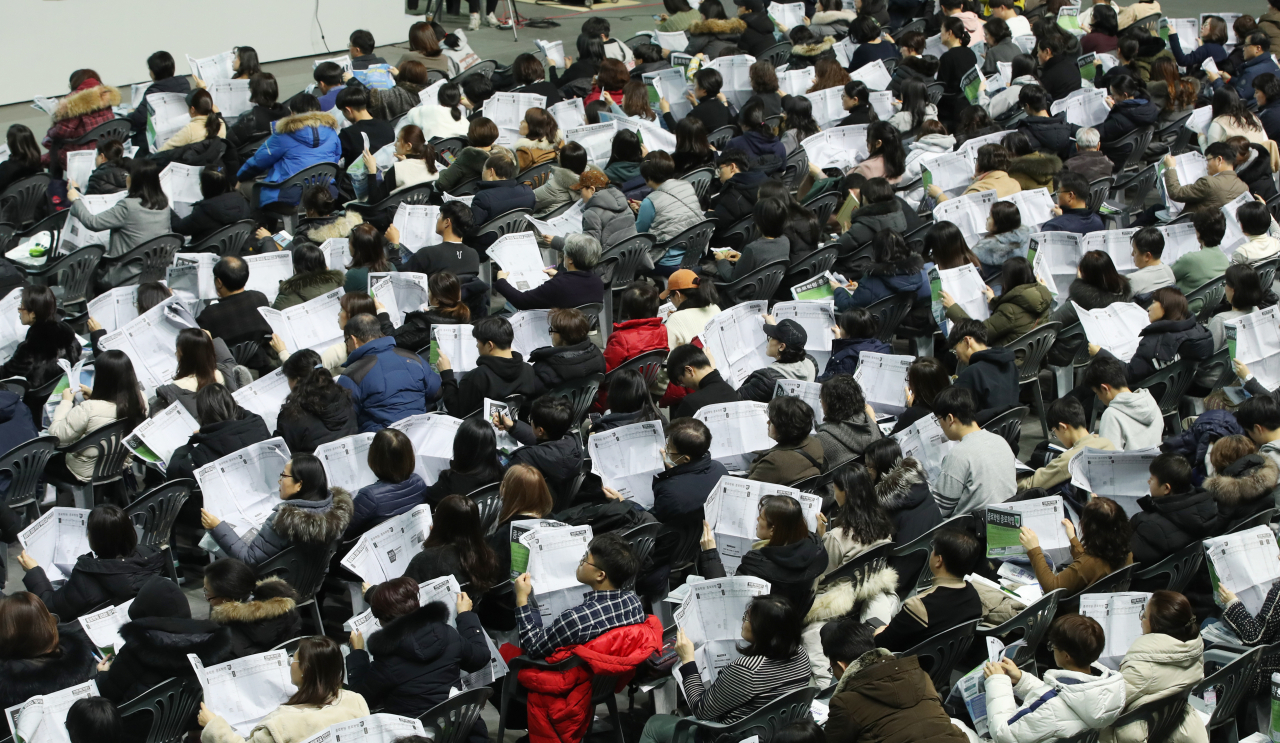 지난해 12월5일 서울 중구 장충체육관에서 열린 종로학원 2020 대입 정시지원전략 설명회에서 수험생과 학부모들이 배치표를 살피고 있다. [연합뉴스]