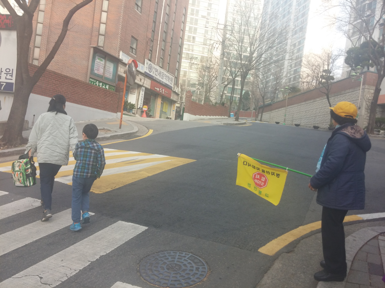 횡단보도 교통지도를 하고 있는 어르신 자원봉사자 모습. [동작구 제공]