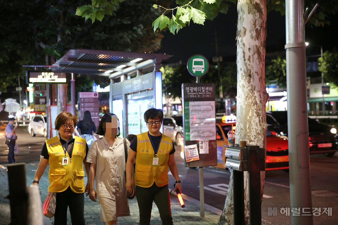 지난해 7월 관악구 서림동 인근에서 일과를 마친 여성이 안심귀가 스카우트들의 동행에 따라 집으로 가고 있다. [관악구 제공]