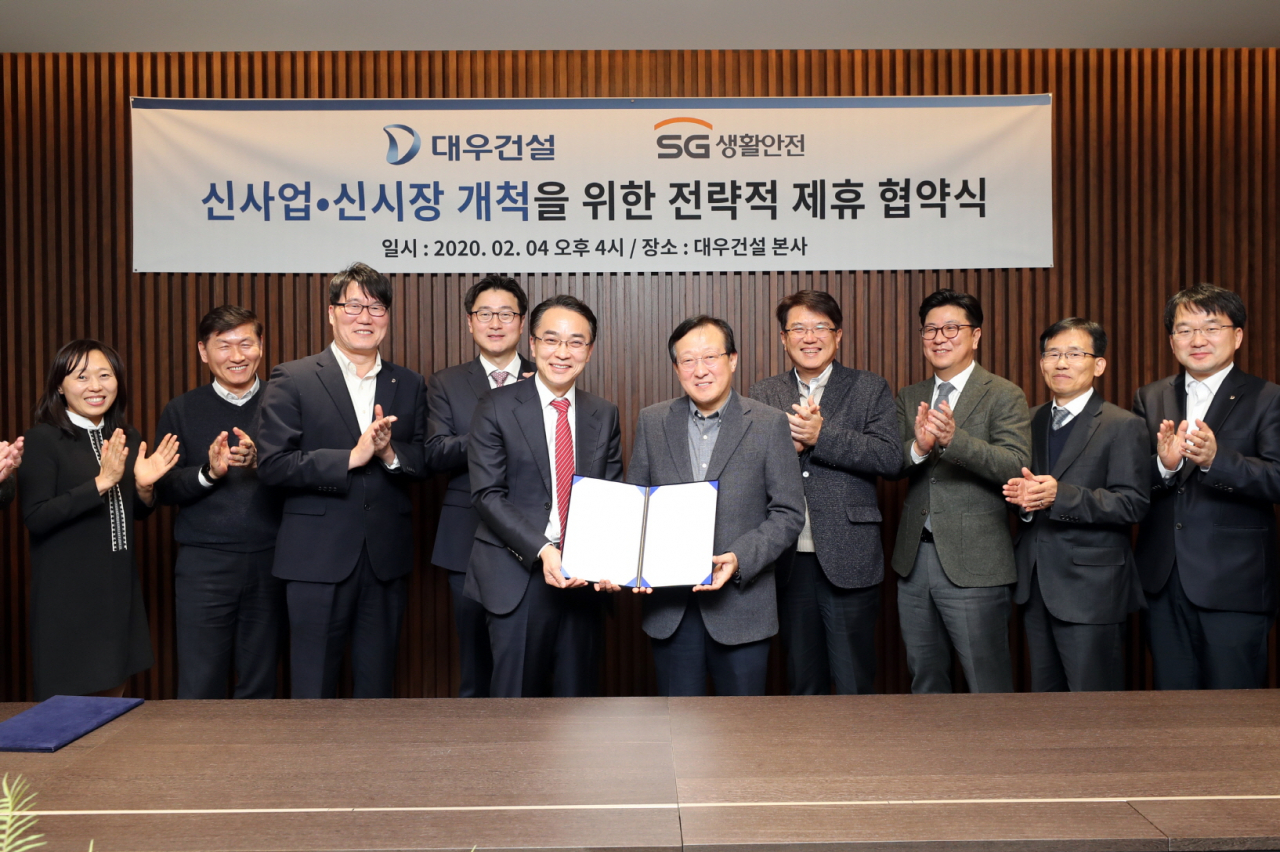 대우건설 신사업본부장 김창환 전무(왼쪽에서 여섯번째), SG생활안전 이상룡 대표(왼쪽에서 다섯번째)가 을지로 대우건설 본사에서 전략적 사업제휴를 위한 양해각서를 체결하고 기념사진을 촬영하고 있다. [대우건설]