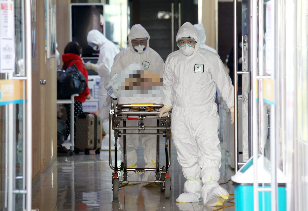 Korea Centers for Disease Control and Prevention officials transfer a patient who had been in isolation at a hosptial in Gwangju to another facility on Wednesday. Yonhap