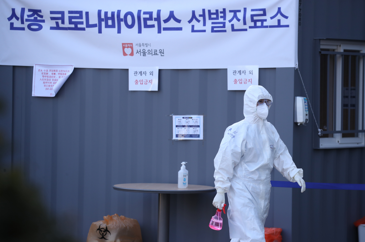 5일 국가지정입원치료병상이 있는 서울 중랑구 서울의료원 신종코로나 바이러스 선별진료소에서 한 의료진이 진료실 소독을 마친 뒤 이동하고 있다. 연합뉴스