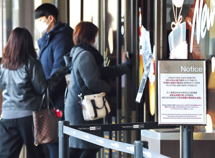 신종 코로나바이러스 감염증 확진자가 다녀가 임시 휴업했다가 7일 영업을 재개한 중구 신라면세점에 마스크 착용 의무 안내문이 써붙어 있다. [연합]