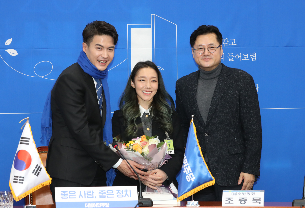 더불어민주당 인재영입 5호인 오영환 전 소방관과 아내인 '암벽여제' 김자인 씨가 7일 오전 서울 여의도 국회에서 열린 영입행사에서 민주당 홍익표 수석대변인과 함께 기념촬영을 하고 있다. 연합뉴스