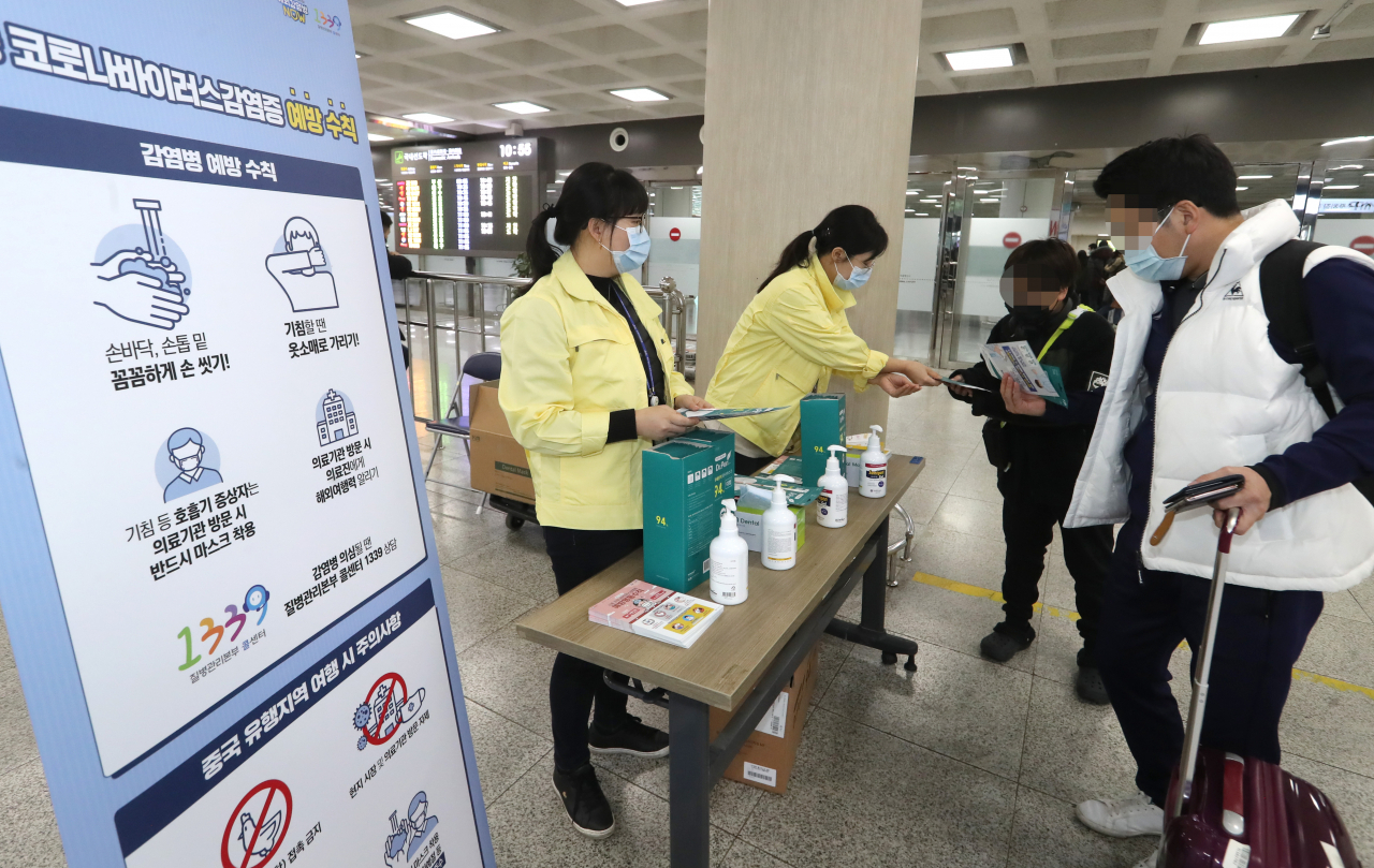 제주도 보건당국 관계자들이 28일 오전 제주국제공항 국내선 도착층에서 신종 코로나바이러스 감염 예방을 위해 마스크 등을 나눠주고 있다. 연합뉴스