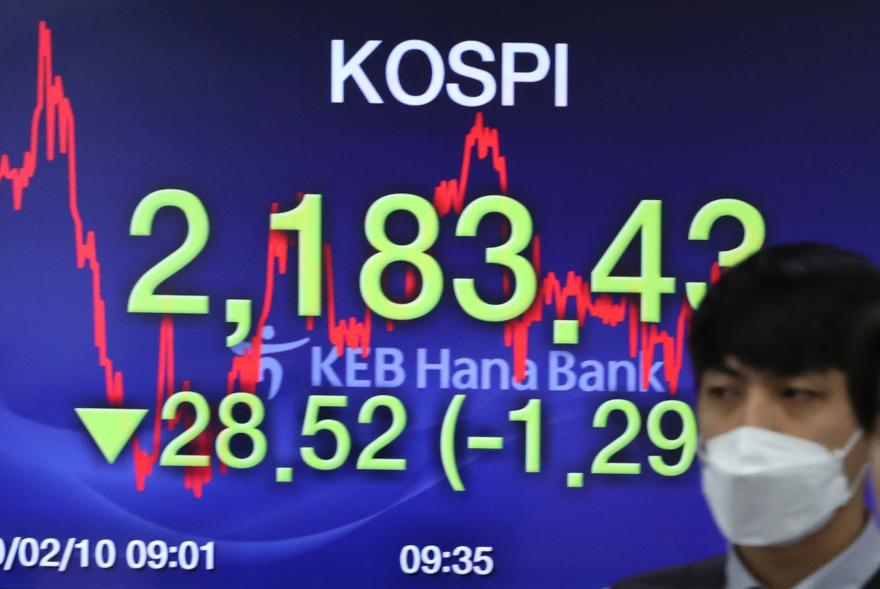 코스피가 하락세로 출발한 10일 오전 서울 하나은행 딜링룸에서 한 딜러가 전광판 앞을 지나고 있다. [연합]