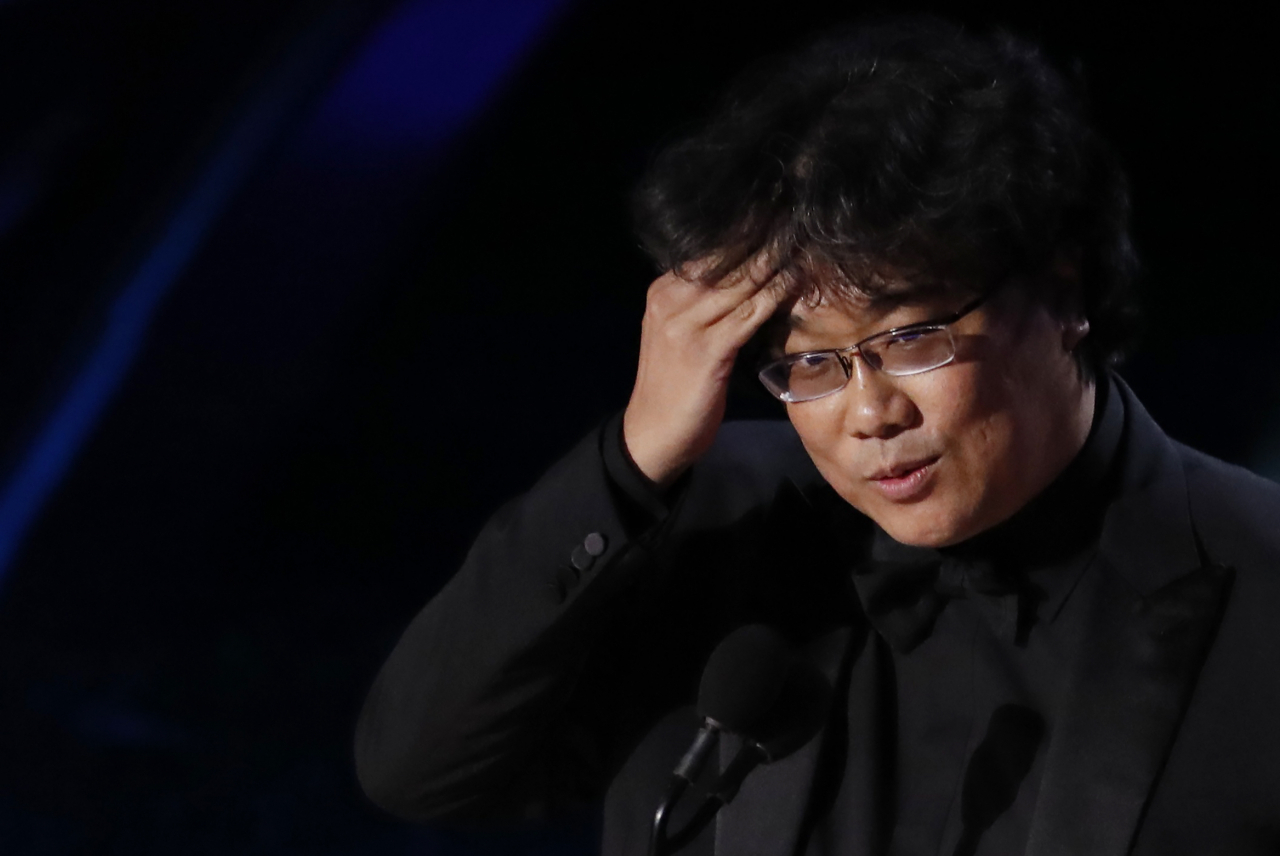‘또 나야?’ 아카데미 감독상까지 수상하며 3관왕이 된 봉준호 감독이 수상소감을 밝히기 전 ‘자꾸 상을 받아 난감하다’는 표정으로 머리카락을 쓸어넘기는 익살스런 제스처를 취하고 있다. [로이터]