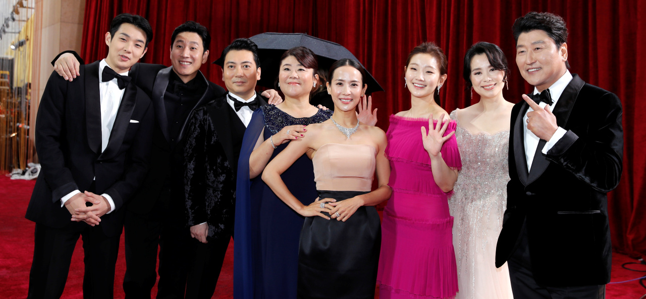 Cast of Parasite including Song Kang-ho Lee Sun-kyun Cho Yeo-jeong Choi Woo-shik Park So-dam Jang Hye-jin Lee Jung-eun and Park Myeong-hoon holding SAG Awards ensemble trophies after Bong Joon-ho's film became the first non-English-language film to win Outstanding Performance by a Cast in a Motion Picture