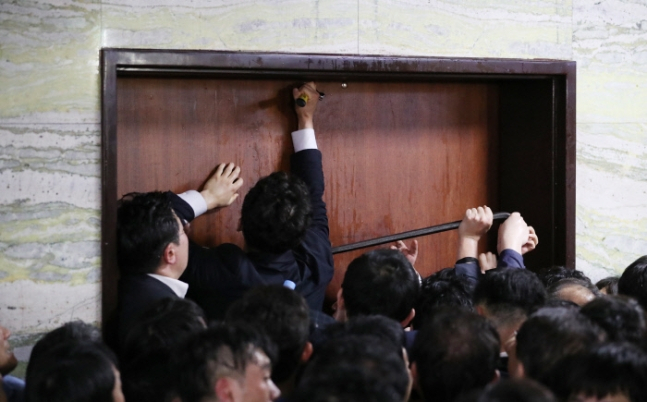 더불어민주당과 국회 관계자들이 지난해 4월 26일 새벽 노루발못뽑이(일명 ‘빠루’)를 이용해 전날 자유한국당이 점거농성한 국회 의안과 문을 열고 진입을 시도하고 있다. [연합]