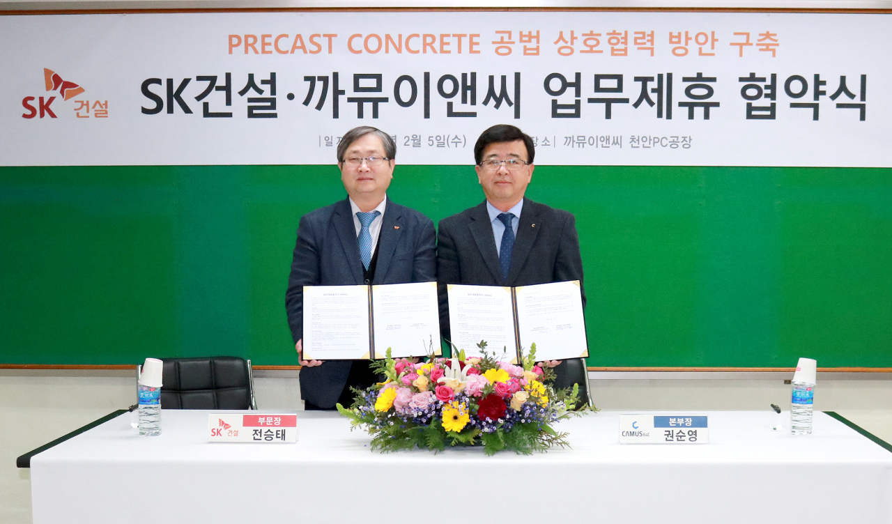 SK건설은 지난 5일 충남 천안시 동남구에 소재한 비즈파트너 까뮤이앤씨 천안PC공장을 방문해 상생·기술협력 MOU를 체결했다고 밝혔다. 전승태 SK건설 건축주택사업부문장(왼쪽)과 권순영 까뮤이앤씨 본부장(오른쪽)이 MOU를 마치고 기념촬영을 하고 있다. [SK건설 제공]