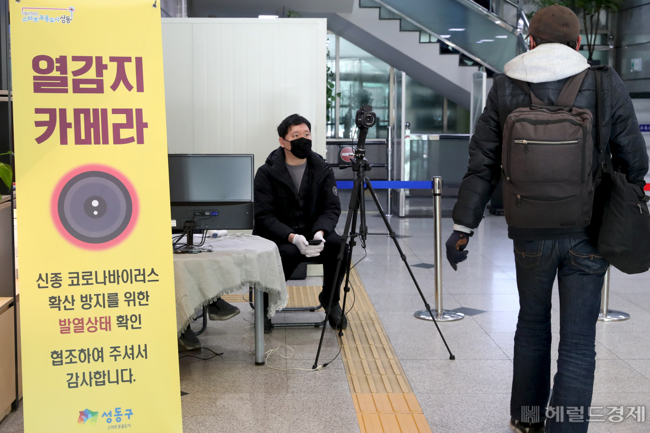 12일 오전 한 시민이 성동구립 도서관에 설치된 열화상 카메라 앞을 지나가고 있다. 성동구는 신종 코로나 바이러스 확산방지를 위해 지역 내 공공시설 45개소에 총 53대의 열화상카메라를 전면 설치, 운영하고 있다.[성동구] 　