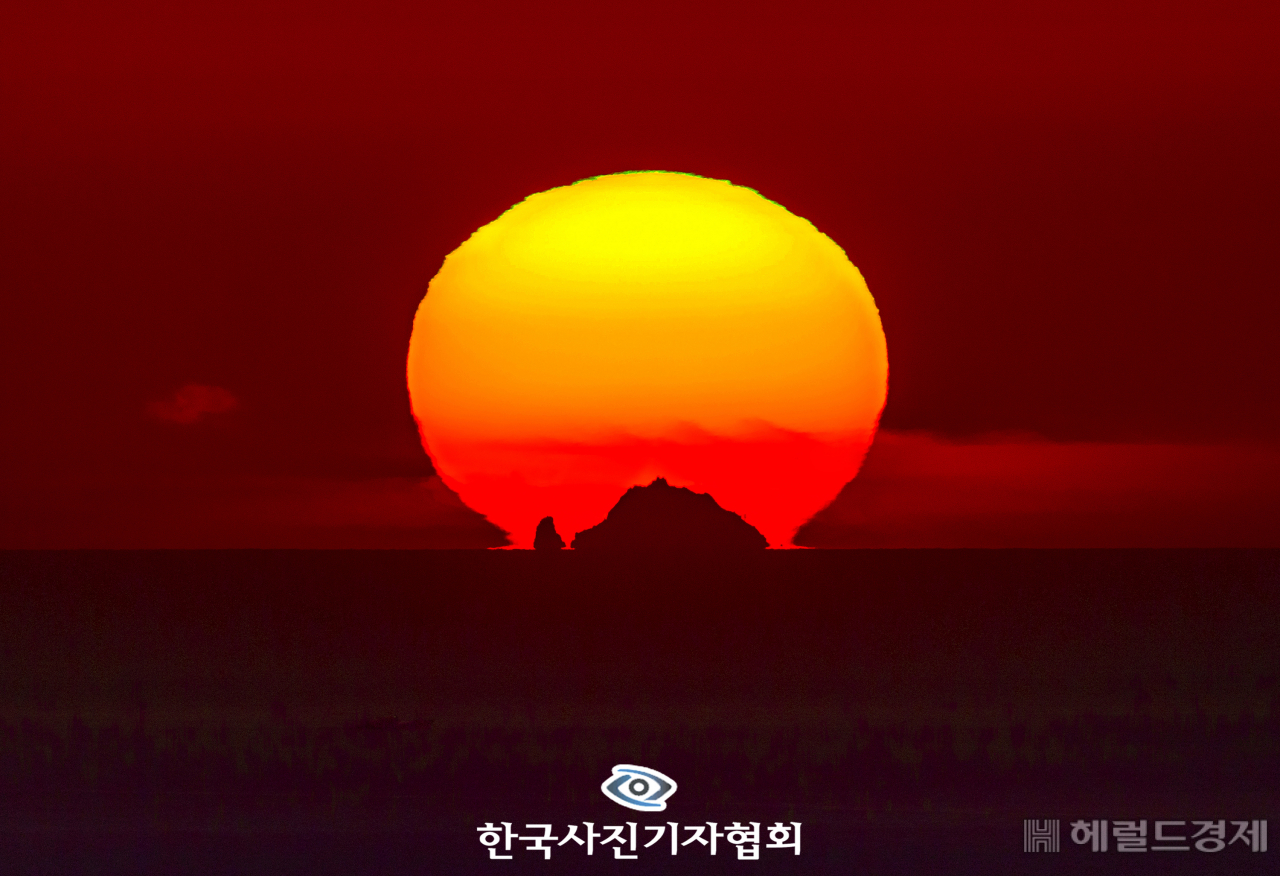 〈56회 한국보도사진상 - 최우수상〉 신경림 시인은 이곳을 가리켜 ‘홀로 있어도 늘 우리들 가슴 한복판에 있는&hellip; 영원한 그리움이고 안타까움’이라고 했습니다. 이곳은 독도입니다. 독도를 품은 태양의 사진을 카메라에 담았습니다. 울릉도에서 남동쪽으로 87.4㎞ 떨어진 독도를 볼 수 있는 날은 1년에 50일 남짓, 독도와 태양을 일직선으로 볼 수 있는 때는 2월과 11월 중 열흘 정도에 불과합니다. 한 달 간의 취재 끝에 대한민국에서 가장 먼저 해가 떠오르는 독도의 ‘황금 일출’ 장면을 포착할 수 있었습니다. 〈윤성호기자/ 국민일보/ 한국사진기자협회 - 무단전재 재배포금지〉