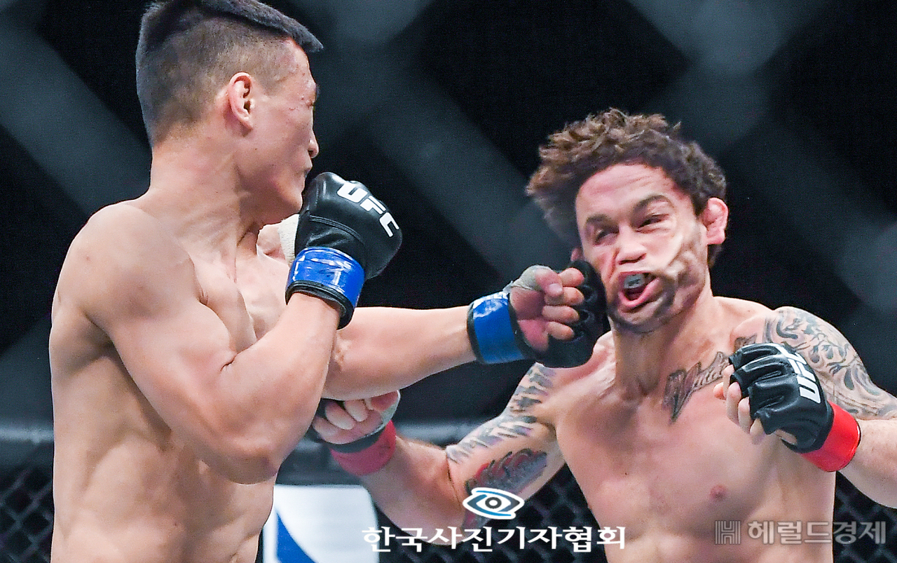 〈56회 한국보도사진상 - 최우수상〉 21일 오후 부산 사직실내체육관에서 진행된 'UFC Fight Night BUSAN' 정찬성과 에드가의 페더급 경기에서 정찬성이 에드카에게 레프트를 날리고 있다. 〈박준형기자/ 오 센/ 한국사진기자협회 - 무단전재 재배포금지〉