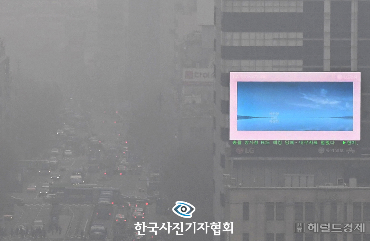 〈56회 한국보도사진상 - 우수상〉 사흘 연속 수도권에 미세먼지 비상저감 조치가 내려진 15일 서울 종로 일대가 한치 앞을 보기 힘들 정도로 뿌옇다. 짙은 미세먼지에 갇힌 도심과 옥외 전광판 속의 파란 하늘이 대조적이다. 〈권현구기자/ 국민일보/ 한국사진기자협회 - 무단전재 재배포금지〉