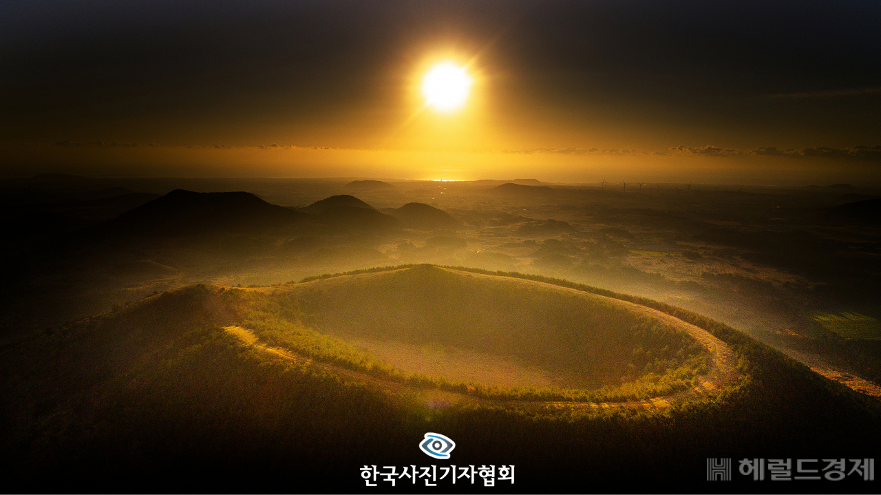 〈56회 한국보도사진상 - 가작〉 2020 경자년(庚子年)을 앞두고 제주 서귀포시 성산읍 백약이오름 위로 해가 힘차게 떠오르고 있다. 경색된 남북 관계, 한국 사회 분열과 갈등, 부동산 문제, 일자리 부족 등이 백약이오름 둘레길의 ‘원’처럼 하나된 마음으로 모든 문제들이 해결되길 바란다. 〈오장환기자/ 서울신문/ 한국사진기자협회 - 무단전재 재배포금지〉