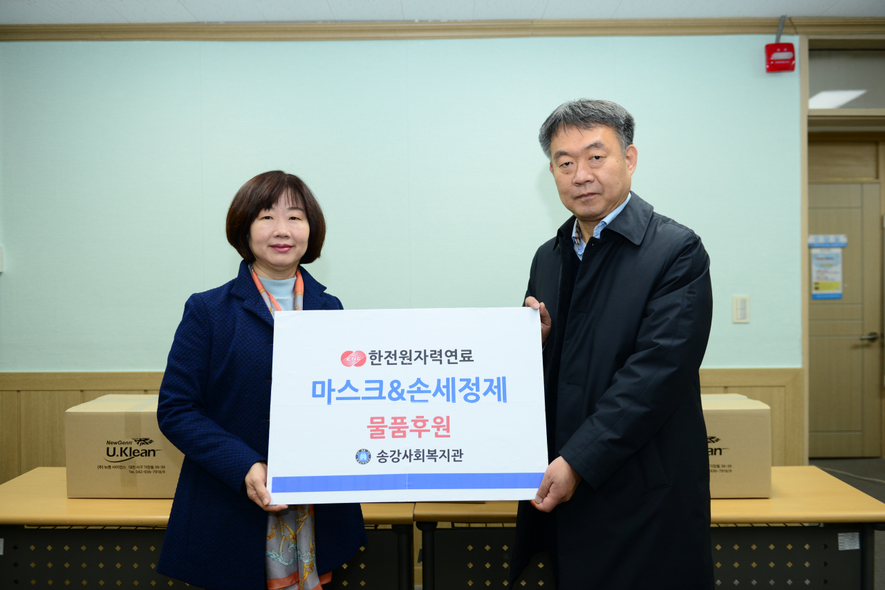 12일 한전원자력연료 이선남(오른쪽) 총무팀장이 송강사회복지관 김영미 관장에게 마스크와 손세정제를 전달하고 있다.[한전원자력연료 제공]