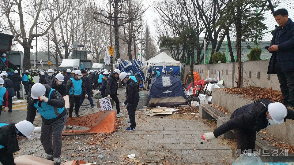 서울시 용역들이 13일 오전 집회 천막을 걷어내고 있다. [서울시 제공]