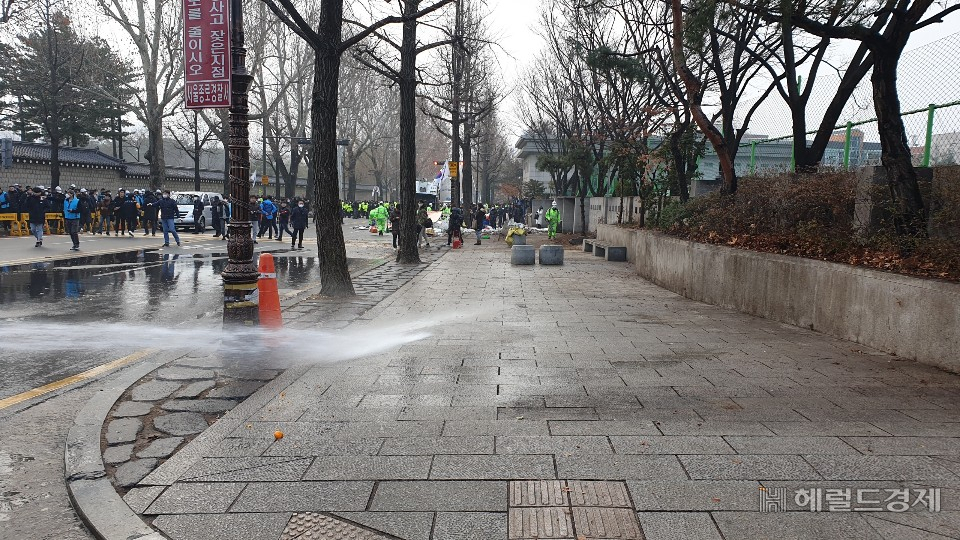 13일 오전 청와대 앞 효자로에서 집회 천막을 치우고 인도에 물을 뿌리고 있다. [서울시 제공]