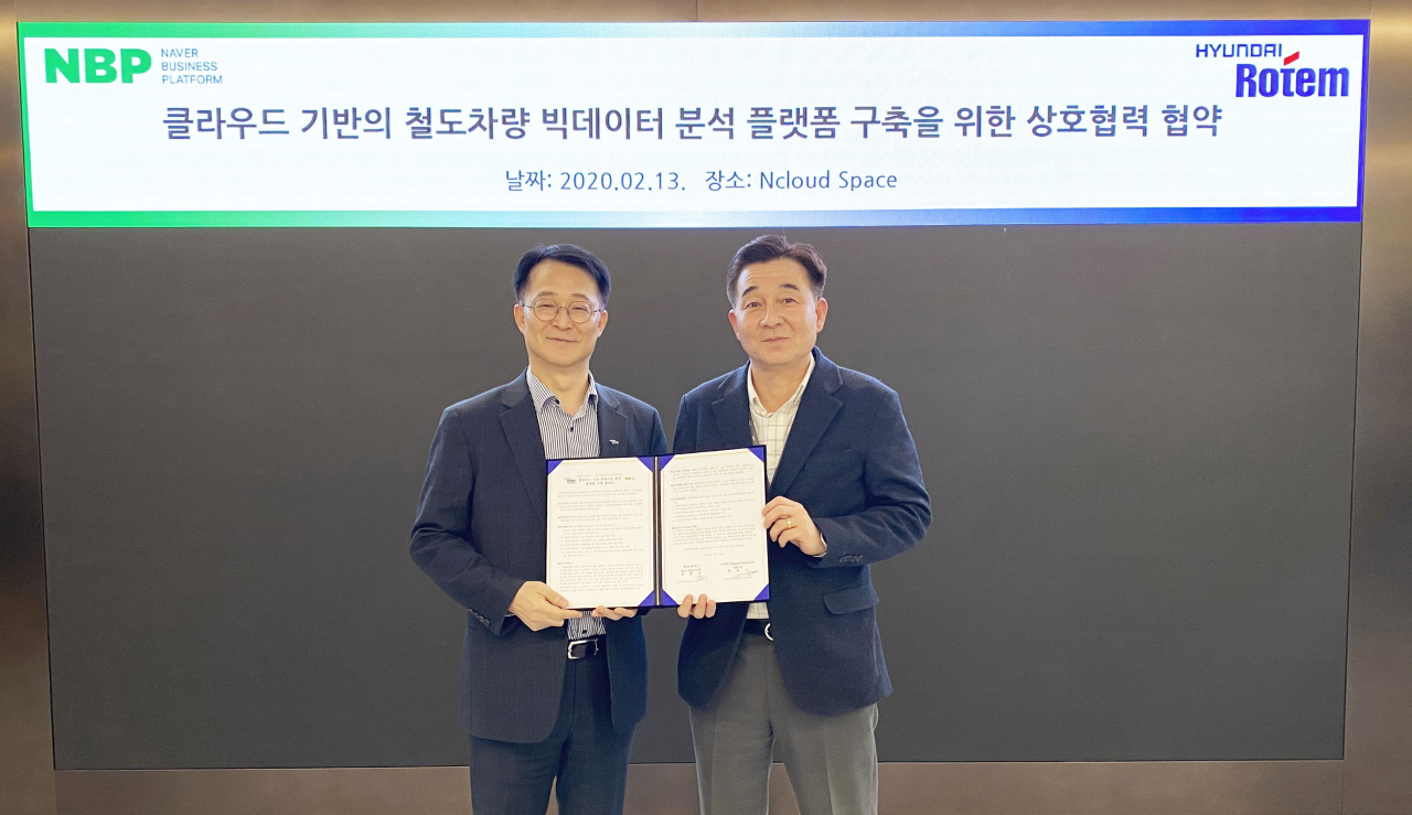 지난 13일 NBP 강남 비즈니스 센터에서 김종년 현대로템 철도기술연구소장(왼쪽)과 NBP 김태창 사업본부장(오른쪽)이 기념촬영을 하고 있다. [현대로템 제공]