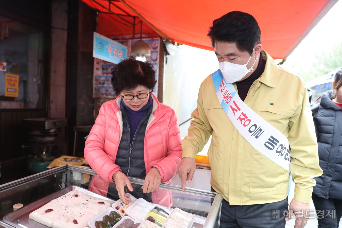 13일 박준희 관악구청장이 전통시장인 조원동 펭귄시장을 찾아 관악사랑상품권으로 떡을 구입하고 있다. [관악구 제공]
