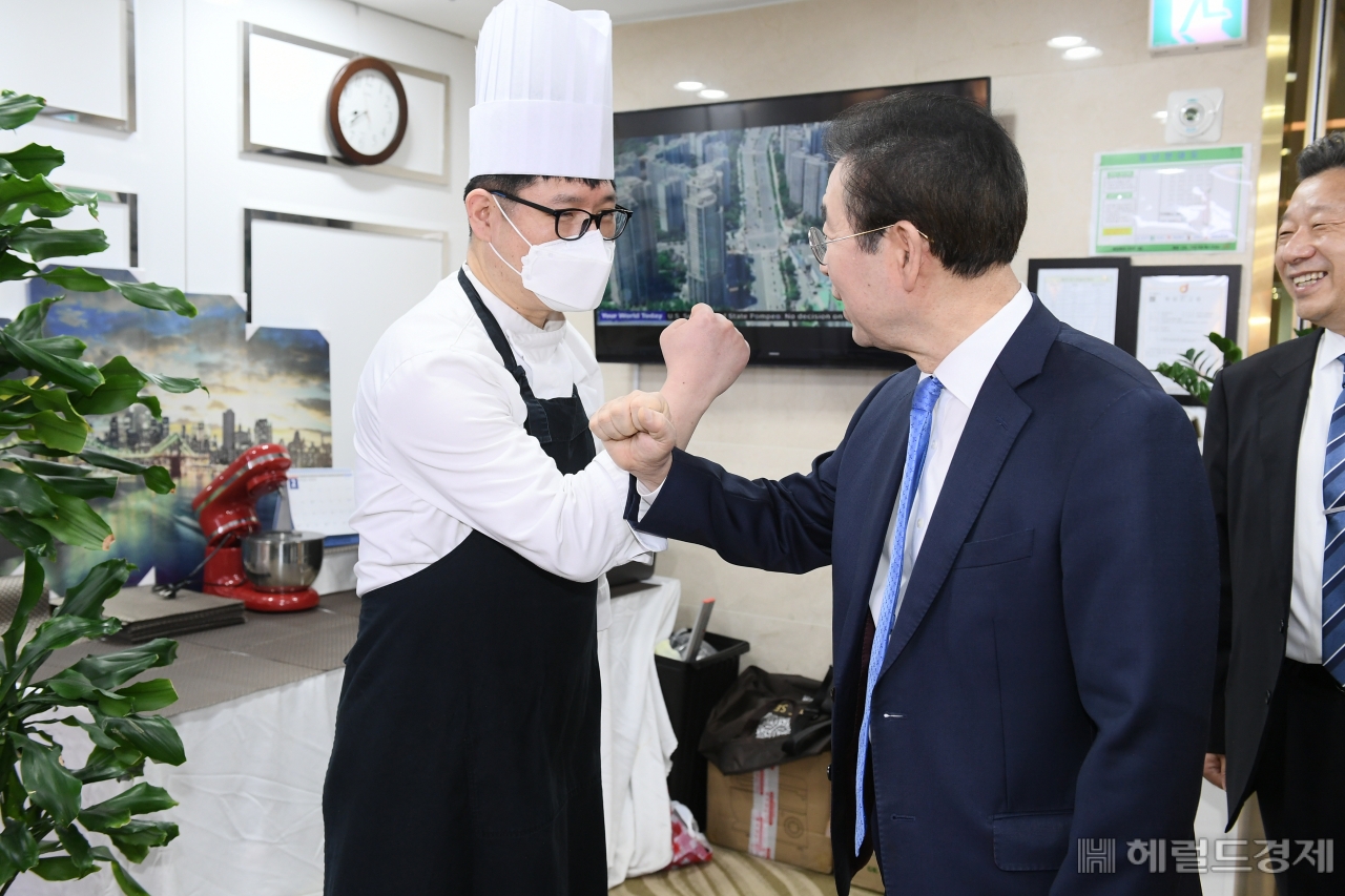 14일 간담회 참석에 앞서 호텔 식당을 돌아 본 박원순 시장이 호텔 직원과 악수 대신 코로나19 예방식 인사를 하고 있다. [서울시 제공]