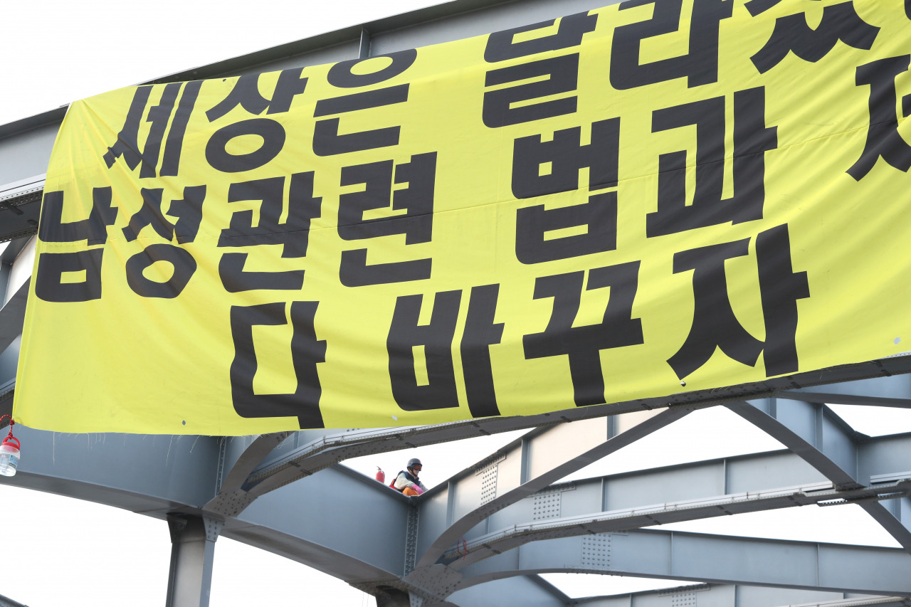 14일 오전 한 남자가 한강대교 아치 위에 올라가 시위를 하고 있다. [연합]
