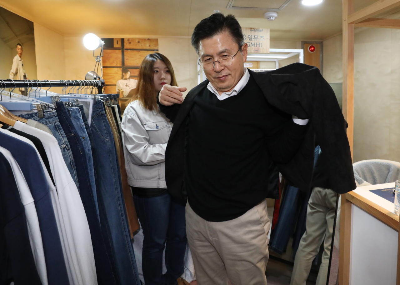 자유한국당 황교안 대표가 14일 오전 서울 종로구 종각역 내 종로청년숲 한 가게에서 옷을 입어 보고 있다. [연합]