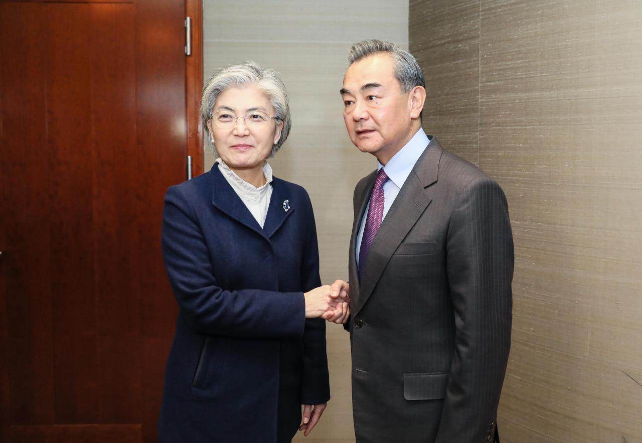 South Korean Foreign Minister Kang Kyung-wha (left) shakes hands with Chinese Foreign Minister Wang Yi during thir meeting on Saturday held on the sidelines of the annual Munich Security Conference. (Ministry of Foreign Affairs)