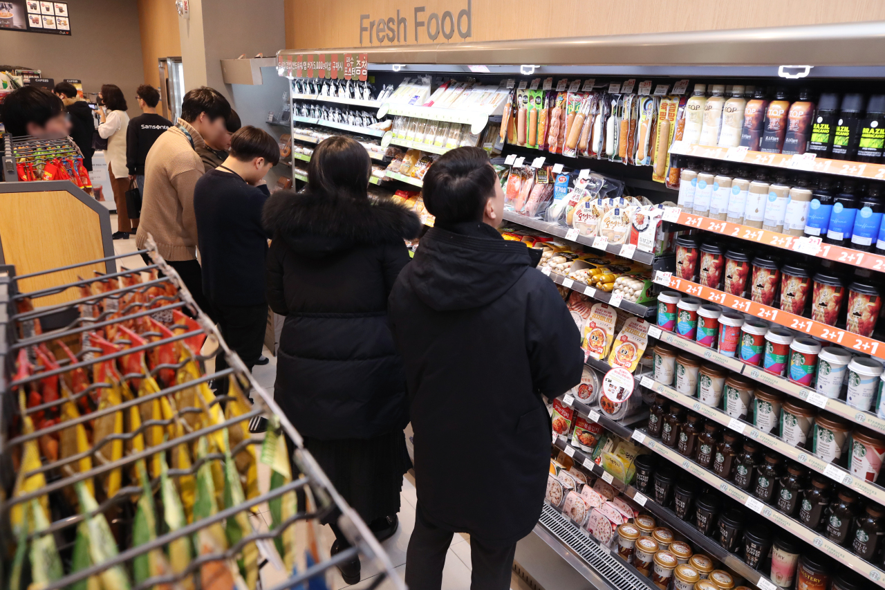 Shoppers browse items at a convenience store in Seoul on Monday. (Yonhap)